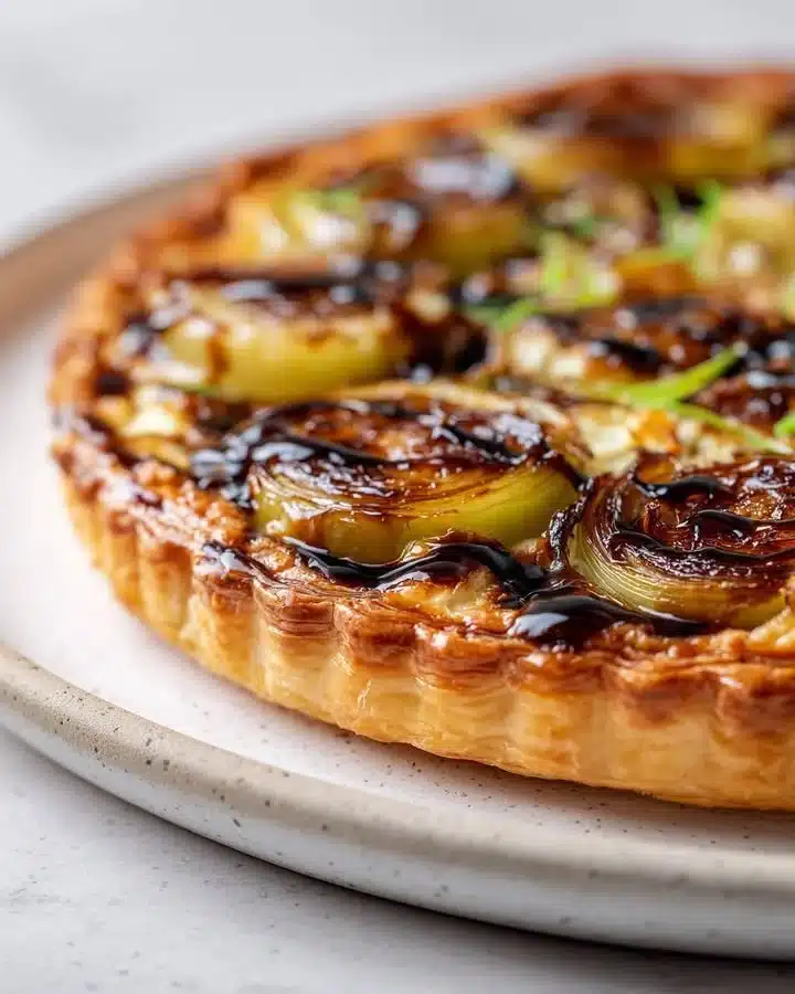 Caramelized leek and Gruyère flip tart served on a wooden table
