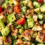 Fresh avocado chicken salad served in a bowl with colorful vegetables