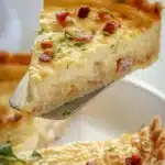 Delicious classic quiche served on a plate with fresh herbs