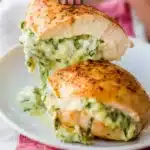 Delicious creamy spinach stuffed chicken on a plate garnished with herbs
