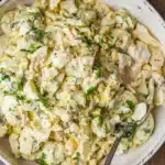 Delicious homemade egg salad in a bowl with fresh herbs and spices.