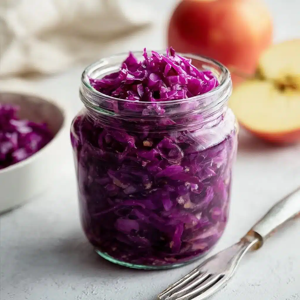 Homemade Ginger Apple Sauerkraut in a glass jar with ginger and apple slices