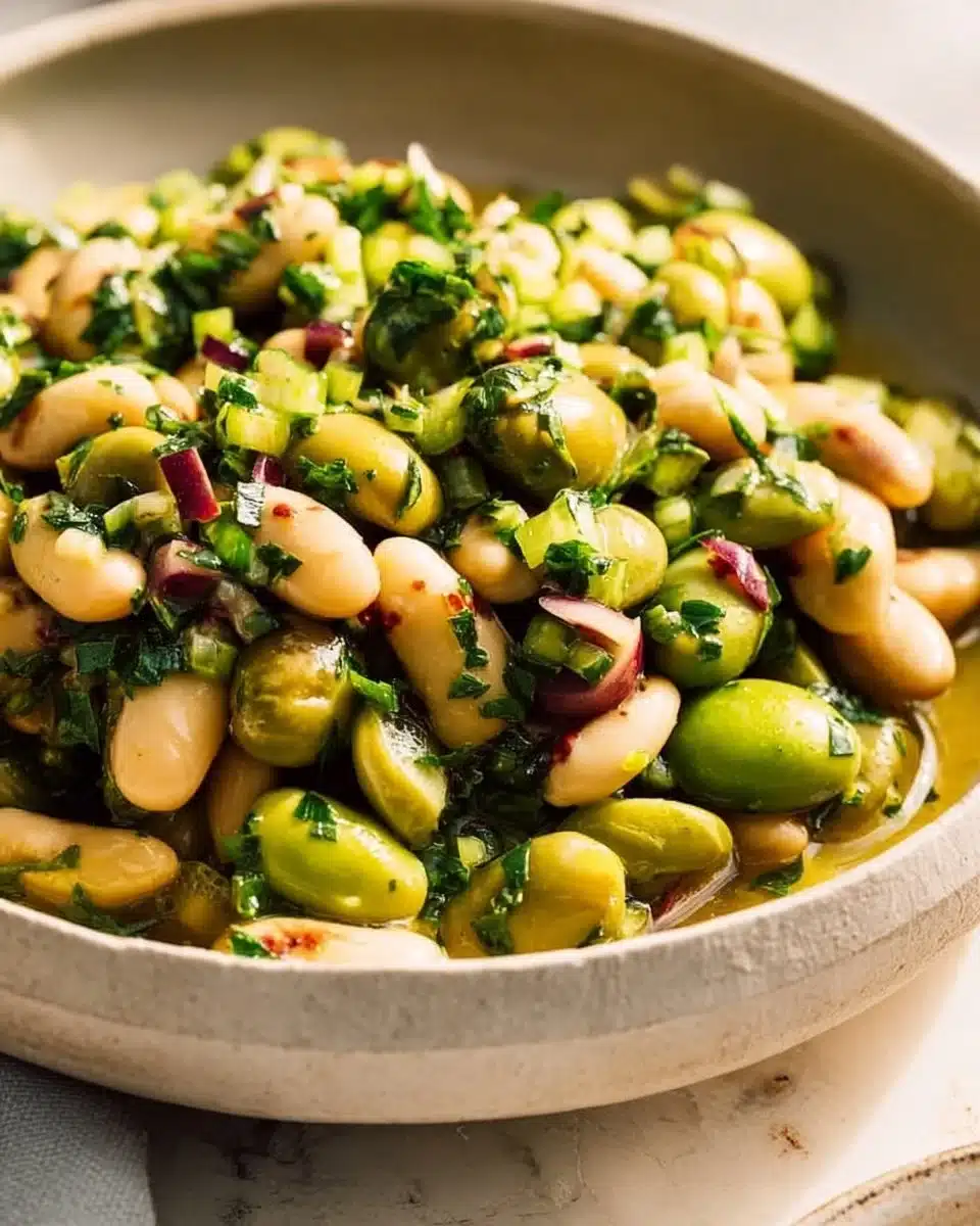 Delicious green olive bean salad served in a bowl topped with fresh herbs