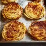 Deliciously roasted cabbage steaks served with seasoning and herbs.