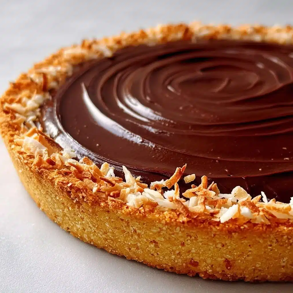 Delicious Chocolate Macaroon Tart served on a white plate with chocolate drizzle